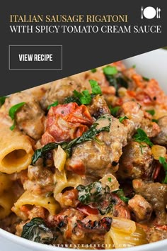 a white bowl filled with pasta covered in meat and vegetables, topped with spinach