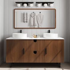 a bathroom vanity with two sinks and a large mirror above it, in front of a white wall