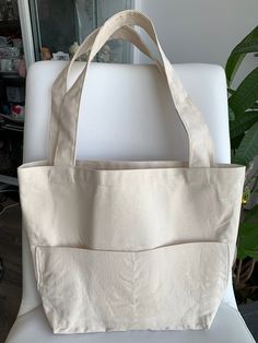 Canvas tote bag is ideal for a trip to the beach or for that quick weekend getaway!  Perfect for everyday, baby mommy bag, quick grocery trip, work bag, craft project bag, or can be used as a gift bag or for your bridal party. Natural textured canvas with 2 large exterior pockets and long comfortable double handles. Measurements: Body (w x h x d): 28 x 30.5 x 12 cm (11 x 12 x 4.75 in.) Handle drop: 30.5 cm (12 in.) If you have any queries, please leave a message. Thank you for visiting us. White Large Capacity Diaper Bag For Daily Use, Eco-friendly Large Capacity Canvas Bag For On-the-go, White Large Capacity Tote Diaper Bag, Large Capacity Cream Tote Beach Bag, Cream Large Capacity Tote Beach Bag, Large Capacity Beige Rectangular Diaper Bag, Large Capacity Rectangular Beige Diaper Bag, Beige Large Capacity Rectangular Diaper Bag, Beige Rectangular Large Capacity Diaper Bag