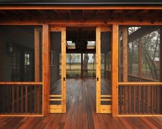 a wooden porch with glass doors and railings