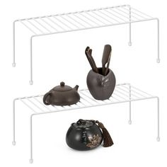 three shelves with pots and spoons on them, one is black the other is brown