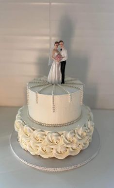 a wedding cake with a bride and groom on top