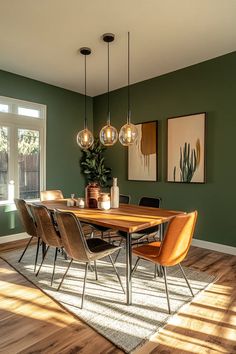 a dining room with green walls and wooden flooring is pictured in this image, there are four hanging lights above the table