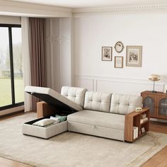 a living room with a sectional couch and open storage compartment on the floor in front of a large window