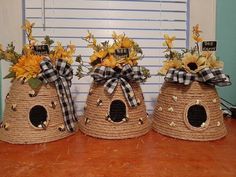 three baskets with sunflowers and other flowers in them are sitting on a table