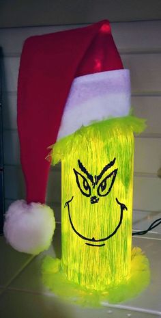 a yellow light up box with a grin face drawn on it and a santa hat