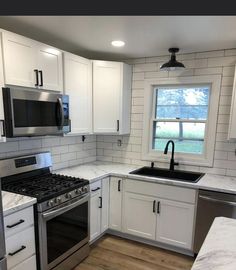 a kitchen with white cabinets and stainless steel appliances