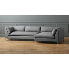 a gray couch sitting on top of a hard wood floor