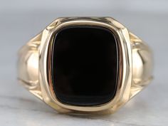 "This vintage men's ring is stylish black onyx and yellow gold, a combination that is sophisticated and traditional. The design of this ring offers a little more size and substance but is still easy to wear! Metal: 14K Yellow Gold Gem: Black Onyx Gem Measurements: 14.0 x 11.0 mm, Cushion Cut Ring Size: 13.75 Marks: \"14K\" Stamped on the inside band SKU #: F5C7A4R6 Each piece has been identified and graded by a Graduate Gemologist who has been certified by the Gemological Institute of America (G Classic Black Rings With Polished Edges, Classic Black Signet Ring With Polished Edges, Timeless Black Signet Ring With Gemstone, Classic Onyx Signet Ring With Black Enamel, Black Polished Signet Ring For Formal Occasions, Classic Black Onyx Signet Ring, Formal Black Rings With Polished Edges, Timeless Onyx Signet Ring With Polished Finish, Classic Onyx Signet Ring With Polished Finish