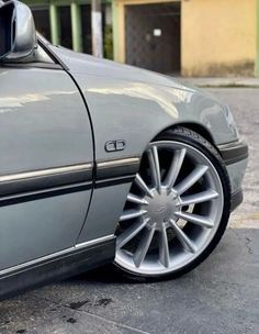 a car parked in a parking lot with its door open and the wheel rims missing