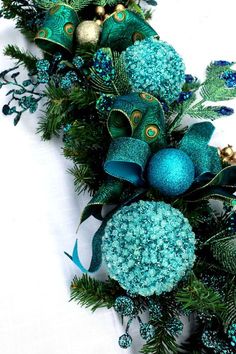 an arrangement of blue and green ornaments on a white surface