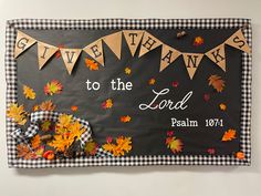 a bulletin board decorated with fall leaves and an image of the words give thanks to the lord