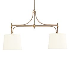 two light chandelier in an antique brass finish with white shades on the lamps