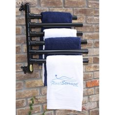 three towels hanging on a towel rack in front of a brick wall with the words heat storage printed on it