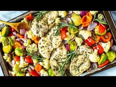 chicken, cauliflower, and vegetables on a sheet pan with a wooden spoon