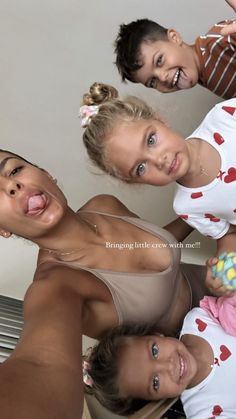 three women and one baby are posing for a photo together with their tongue hanging out