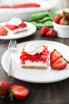 a slice of strawberry cheesecake on a plate with strawberries and whipped cream around it