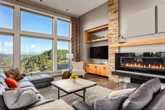 a living room filled with furniture and a fire place in front of a large window