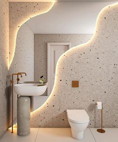 a bathroom with a white toilet sitting next to a sink under a light on the wall