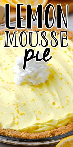 a lemon mousse pie with whipped cream on top and sliced lemons in the background