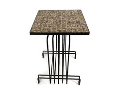 a table that has some sort of metal frame on it with a mosaic tile top