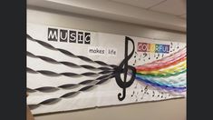 a wall hanging on the side of a building with music notes and rainbows painted on it