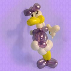 a balloon duck holding a butterfly on a purple background