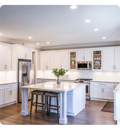 a large kitchen with white cabinets and stainless steel appliances