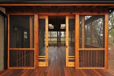 a wooden porch with glass doors and railings