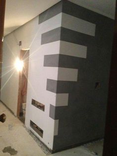 a room that is being painted with black and white stripes on the side of it