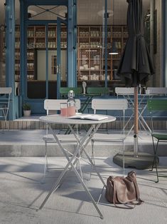 an empty table and chairs in front of a building