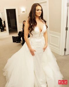 a woman in a wedding dress posing for the camera