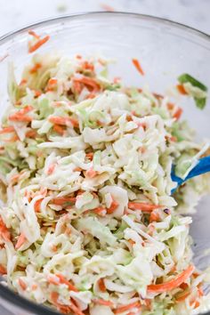 a glass bowl filled with coleslaw and carrots