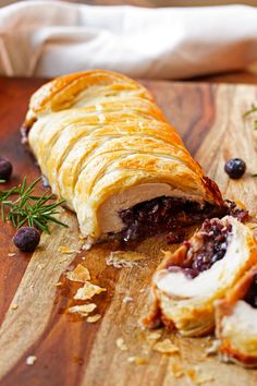 the pastry is cut in half and ready to be eaten with blueberries on the side