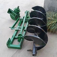 two large metal wheels sitting next to each other on the ground in front of a planter