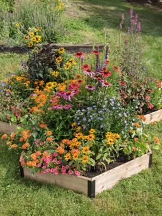 a garden filled with lots of different types of flowers on top of green grass covered ground