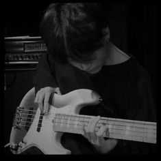 a man playing an electric bass guitar in black and white