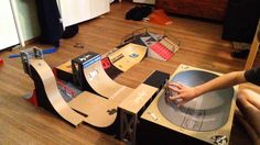 a person is working on a skateboard ramp in a room with wooden floors and hard wood flooring