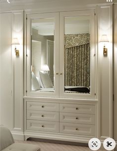 a large white closet with mirrored doors and drawers