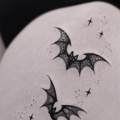 two bats flying in the sky with stars on their back side tattoo designs for women