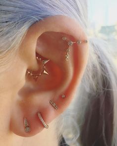 a woman wearing gold ear piercings with diamonds