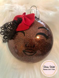 a brown ornament with a red bow on it's head and hair