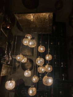 a bunch of lights hanging from the ceiling in a room with black walls and flooring