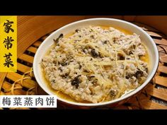 a bowl filled with food sitting on top of a wooden table next to chinese characters