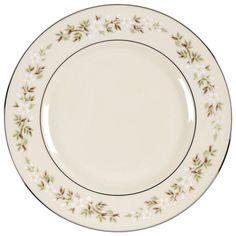 a white plate with green and brown flowers on the rim, against a white background