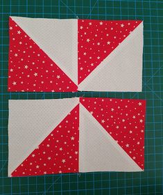 two red and white quilt blocks on a green cutting mat