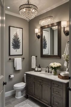 a bathroom with a chandelier, vanity and toilet in the middle of it