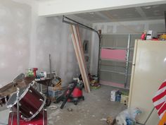 a room that is being remodeled and filled with items for repair, including a drum set