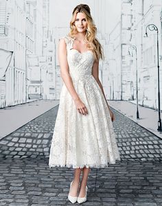 a woman in a white dress standing on a brick road