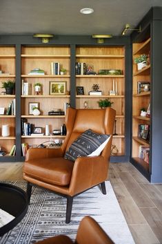 a living room filled with lots of furniture and bookshelves covered in wooden shelves